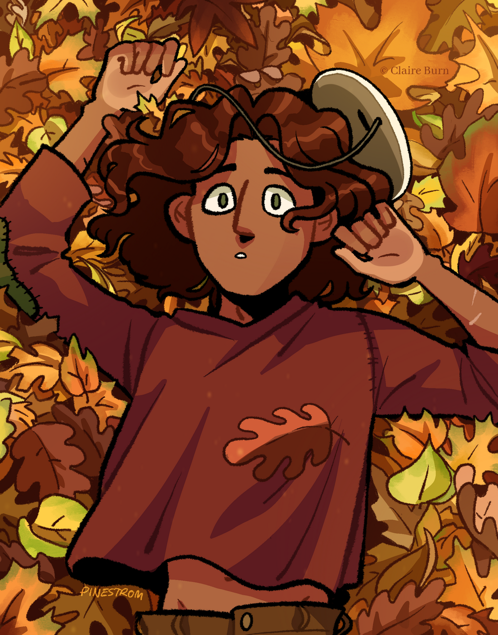 A boy lies in a pile of autumn leaves.